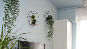 Un salón moderno con un televisor de pantalla plana grande, suelo de madera y una puerta blanca.
