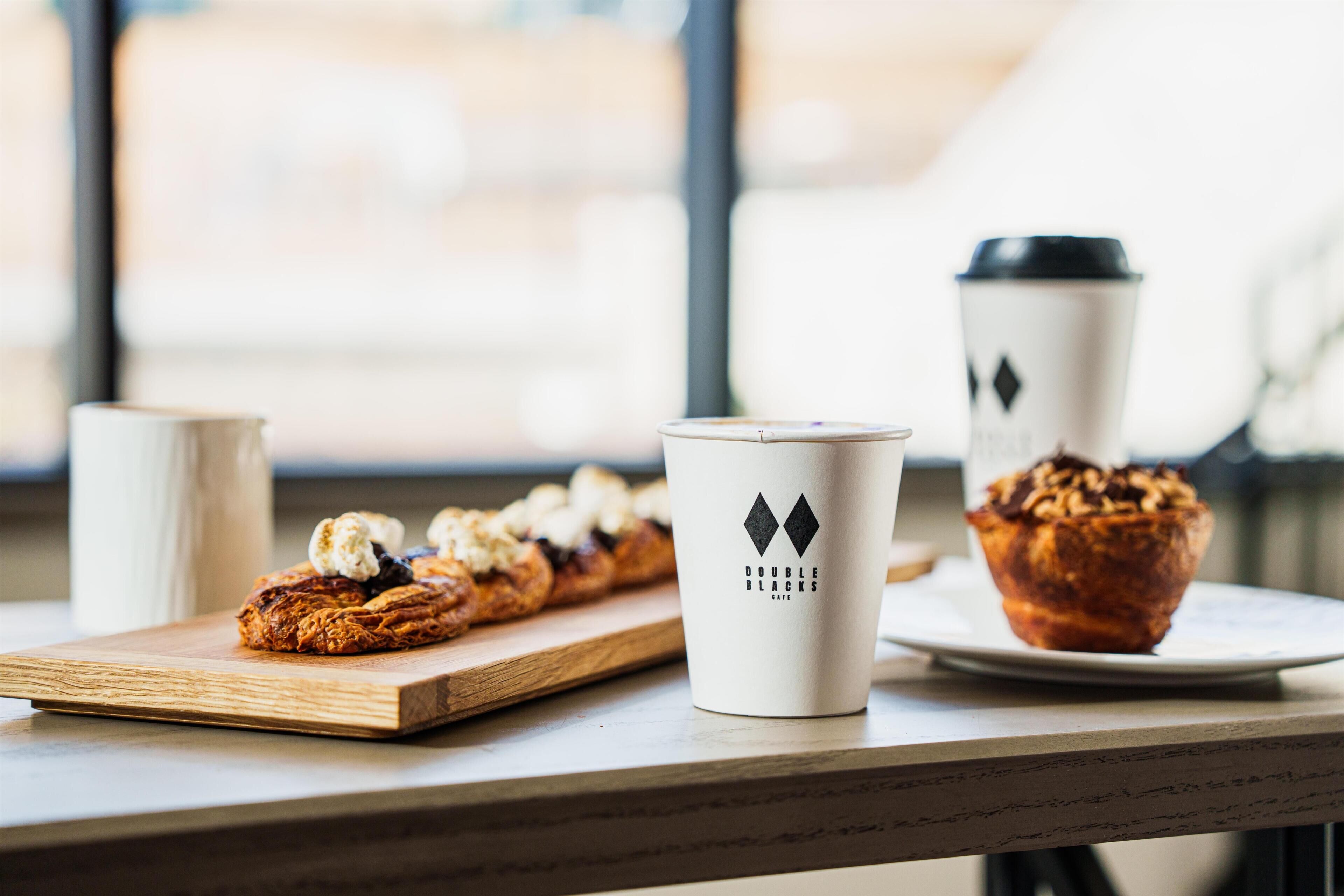 A table with a pastry, a muffin, and a coffee cup with a logo.