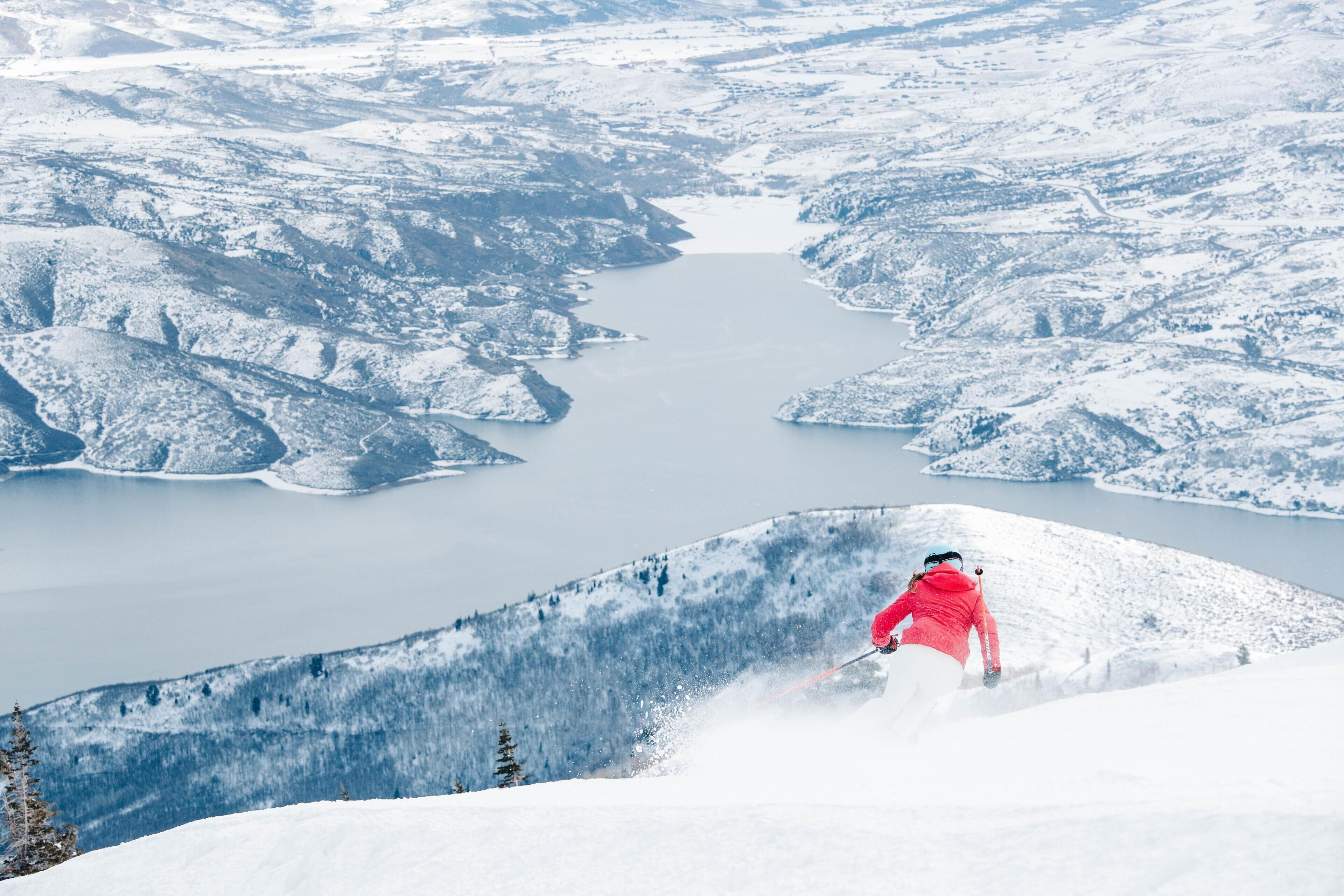 A snowy landscape with a lake and mountains.