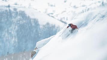 Pendiente nevada de una montaña con un esquiador.