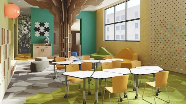 Learn and create in this bright, inviting space with tables for group activities and educational materials on the walls.