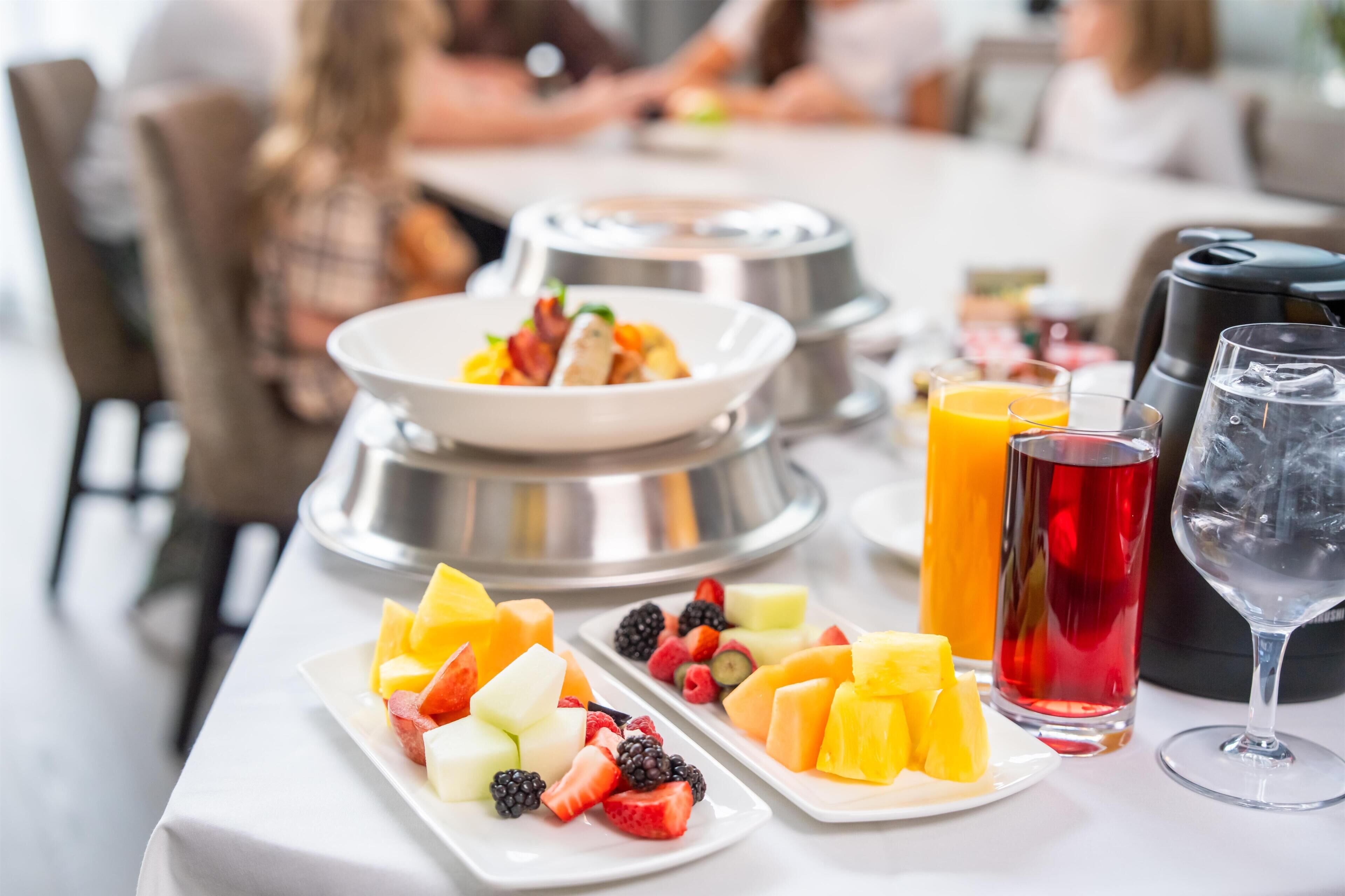 A breakfast buffet with various fruits and beverages.