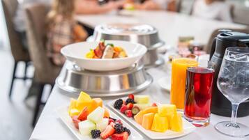 A breakfast buffet with various fruits and beverages.