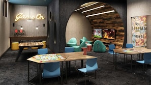 Relax and unwind in this lounge area, featuring a 'Game On' sign, comfortable seating, and a large wall-mounted TV for sports enthusiasts.