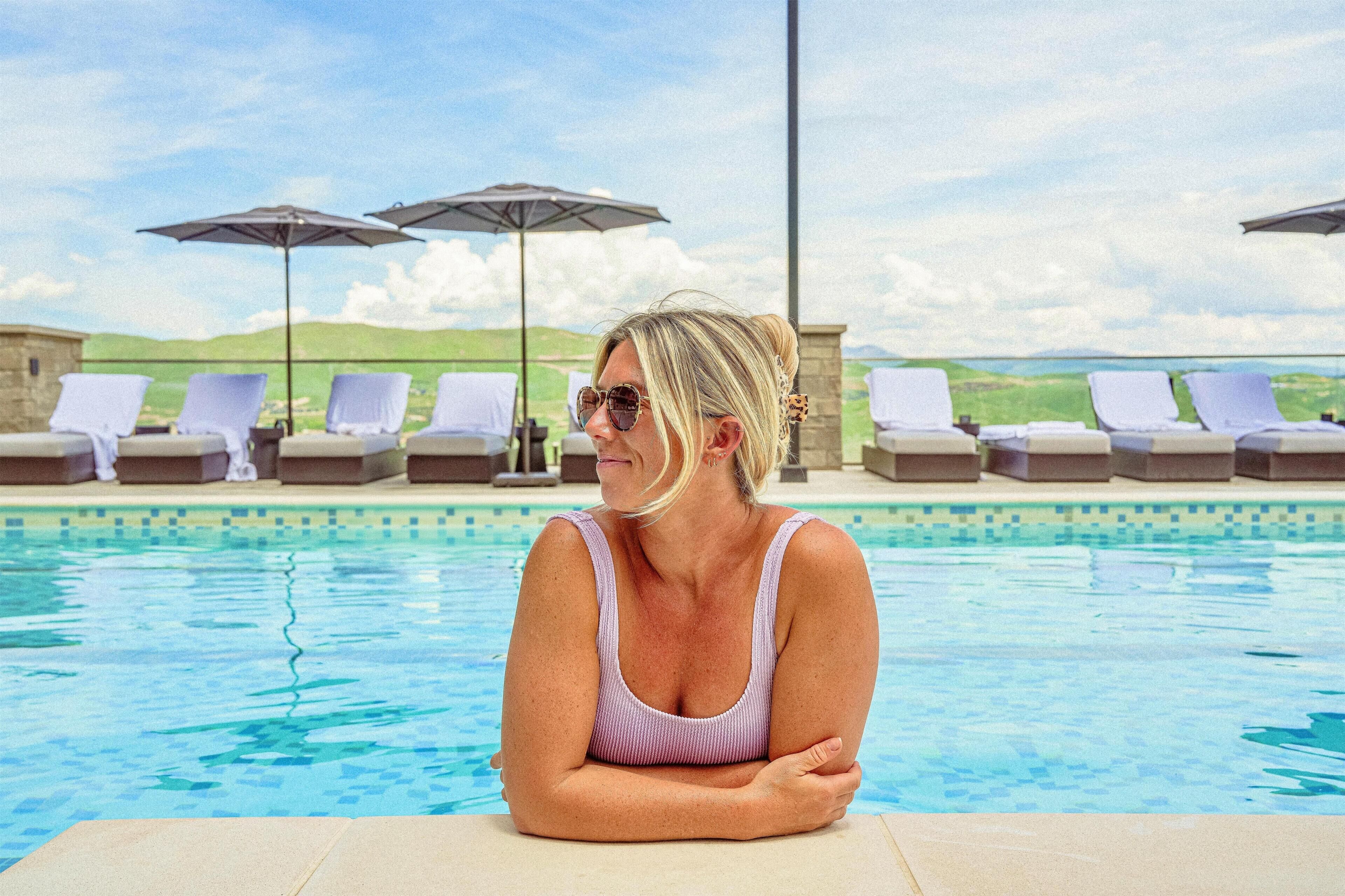 Uma área de piscina com espreguiçadeiras e guarda-sóis.