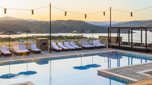 A pool with lounge chairs and umbrellas, a clear view of mountains, and a serene sunset. - Grand Hyatt Deer Valley (Park City)