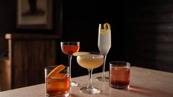 Four glasses of beverages on a table.