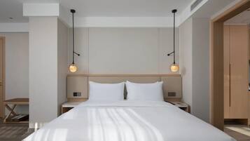 Una habitación de hotel moderna con una cama grande, dos mesitas de noche y un armario de madera.