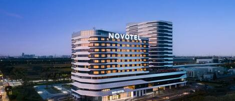 A Novotel hotel with a modern design, featuring multiple floors and a prominent curved structure.