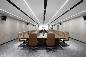 A conference room with a long table, beige chairs, and a large screen at the front. - Novotel Jiaxing Port Area (Jiaxing)