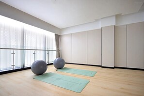 A spacious room with large windows, a wooden floor, two exercise balls, and two yoga mats. - Novotel Jiaxing Port Area (Jiaxing)