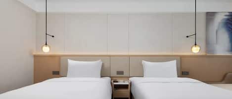 Ein Hotelzimmer mit zwei Betten, einem Nachttisch und einem Bild an der Wand.