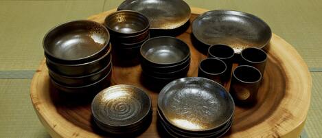 A wooden tray with various black bowls and cups.