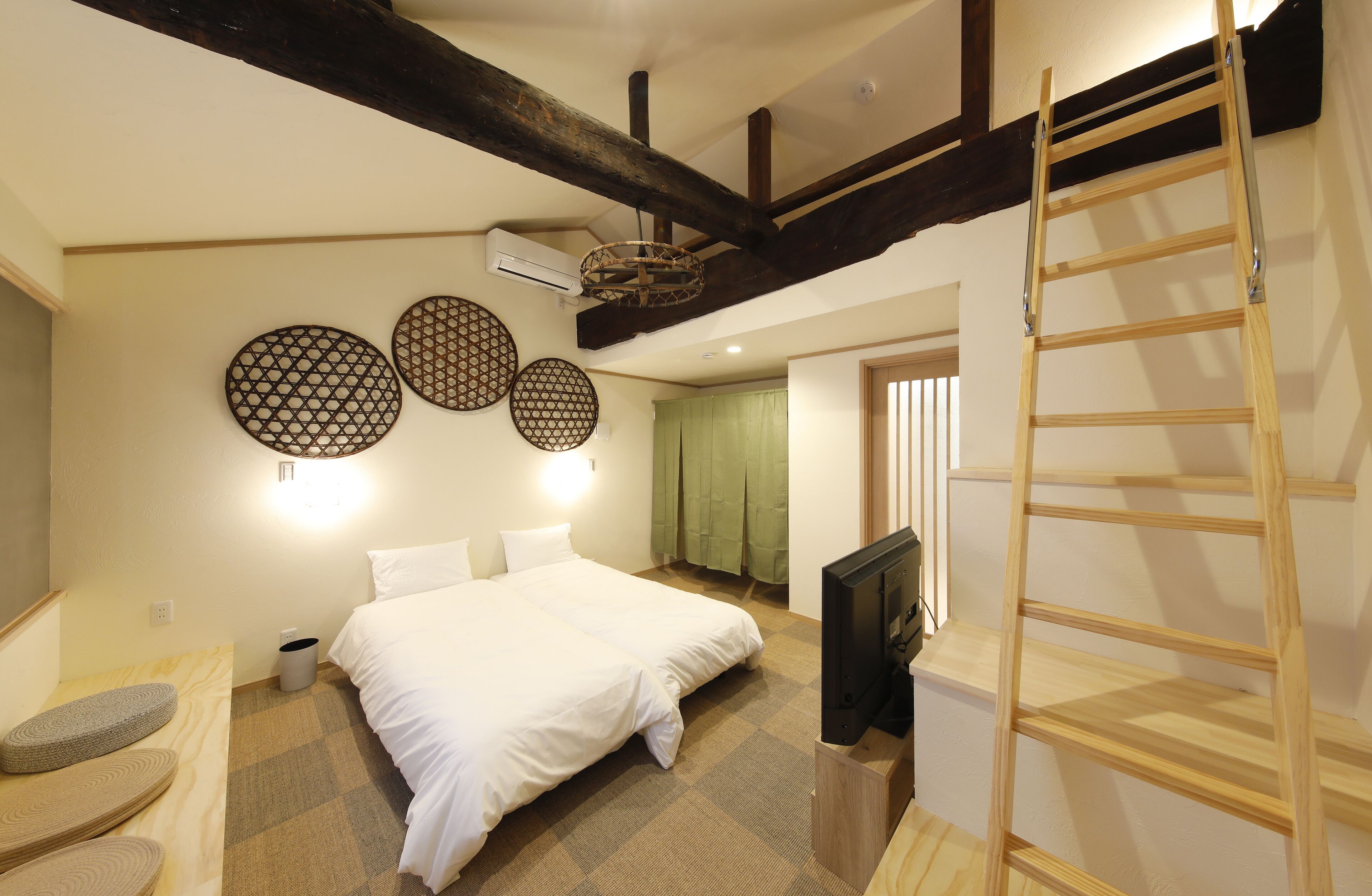 Ein Hotelzimmer mit einem Bett, einem Fernseher, einer Leiter und Wanddekoration.