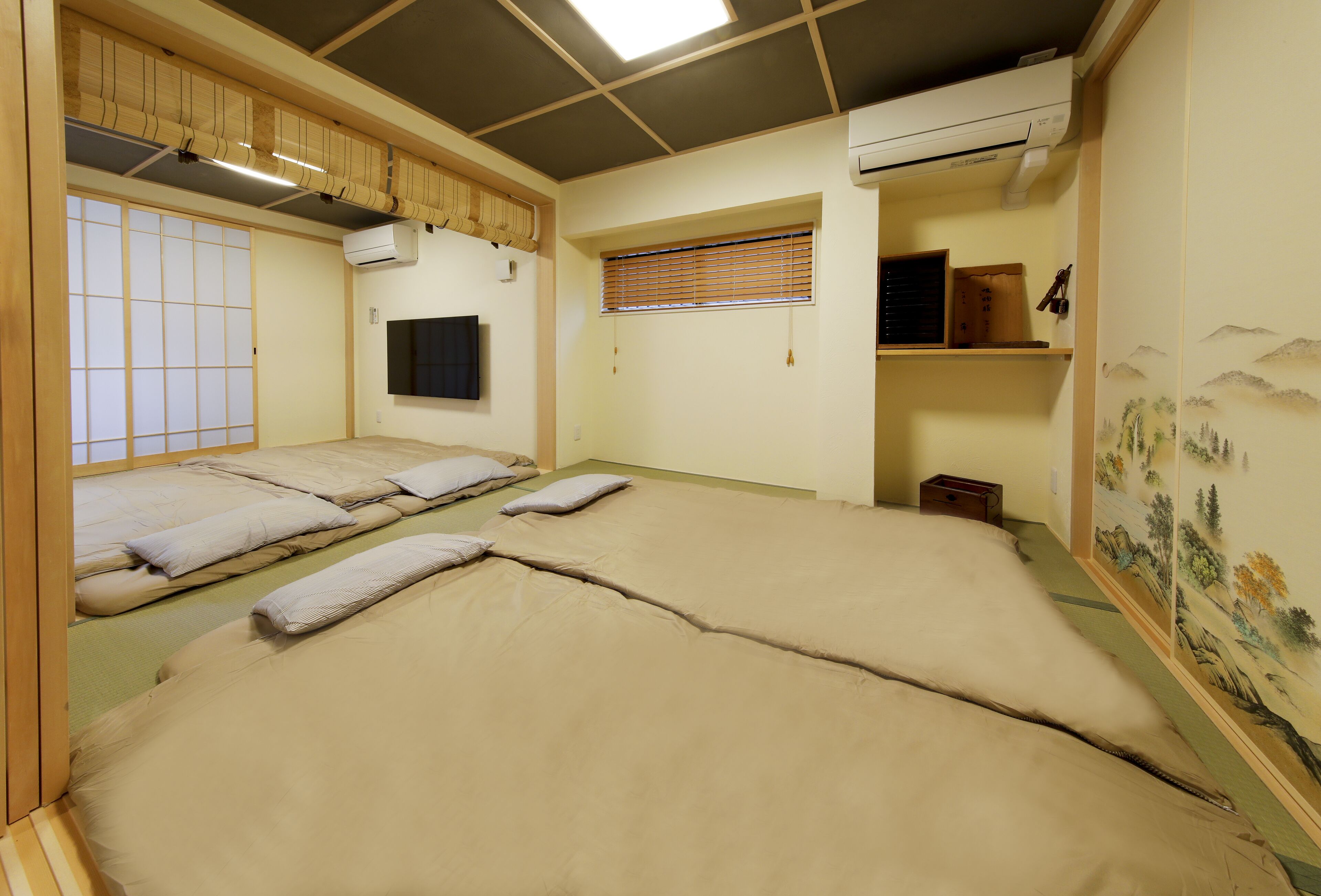 Une pièce de style japonais traditionnel, avec des tatamis, un paravent shoji et un futon servant de lit.