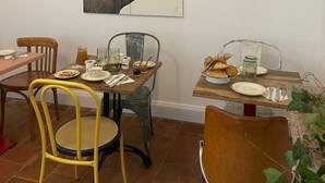 A dining area with a table set for two, featuring a painting of an ostrich on the wall. - maison seize (Perche-en-Noce)