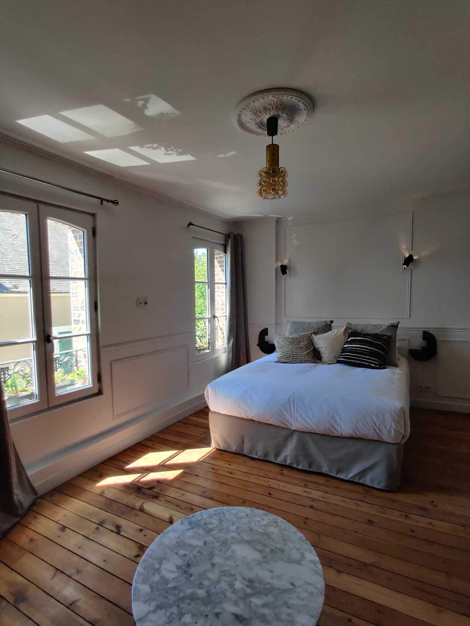 Un dormitorio con una cama, una mesa redonda de mármol y un ventilador de techo.