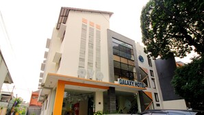 A Galaxy Hotel with a modern design, featuring a prominent entrance and a visible staircase leading to the lobby. - Capital O Galaxy Inn (Bandung)
