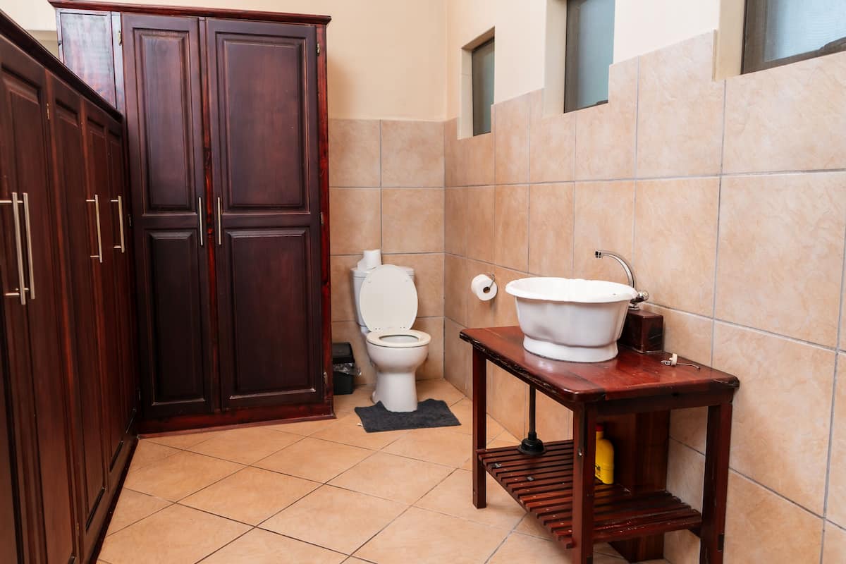 Bathroom features a toilet, basin, and wardrobe.