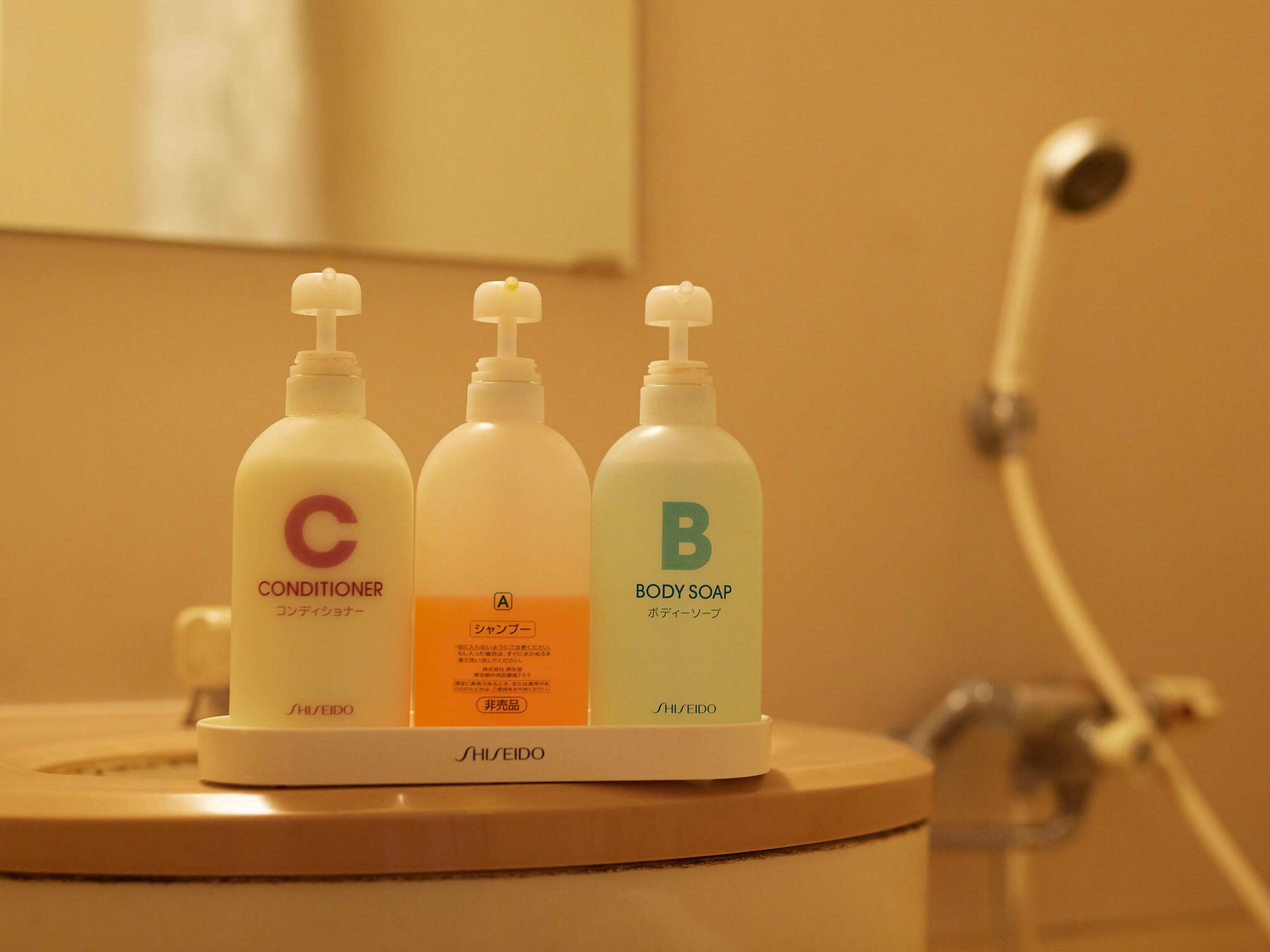 Three bottles of personal care products on a bathroom counter.
