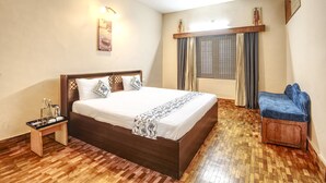 Een slaapkamer met een houten bed, nachtkastje en een blauwe stoel.