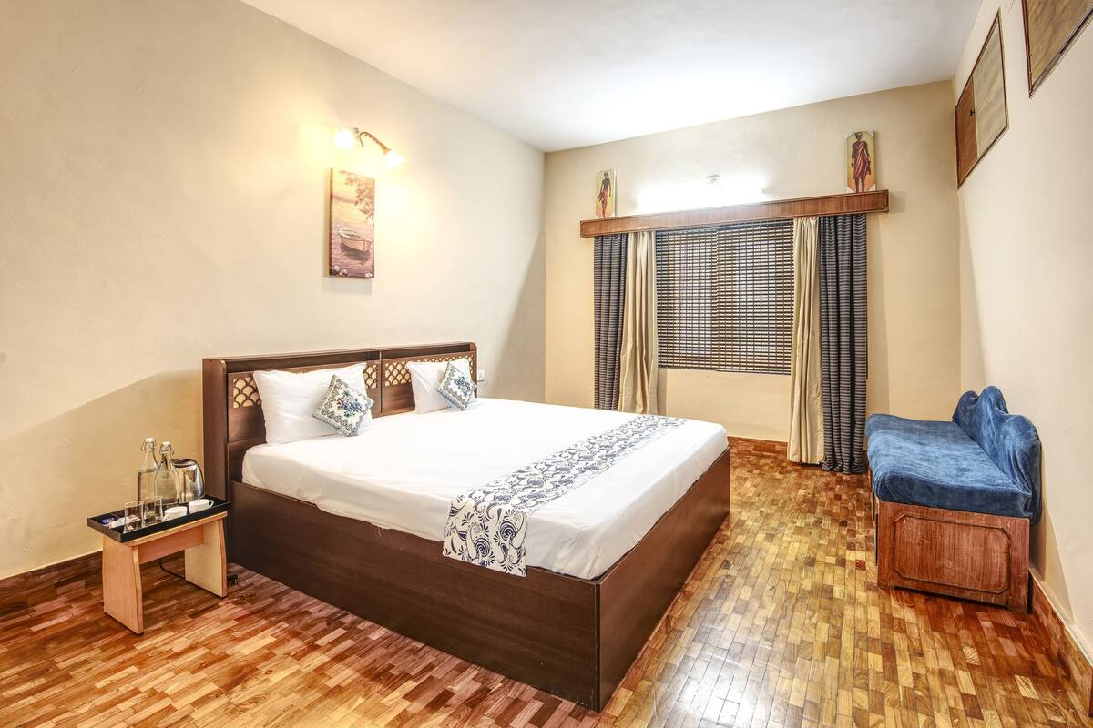 A bedroom with a wooden bed, bedside table, and a blue chair.