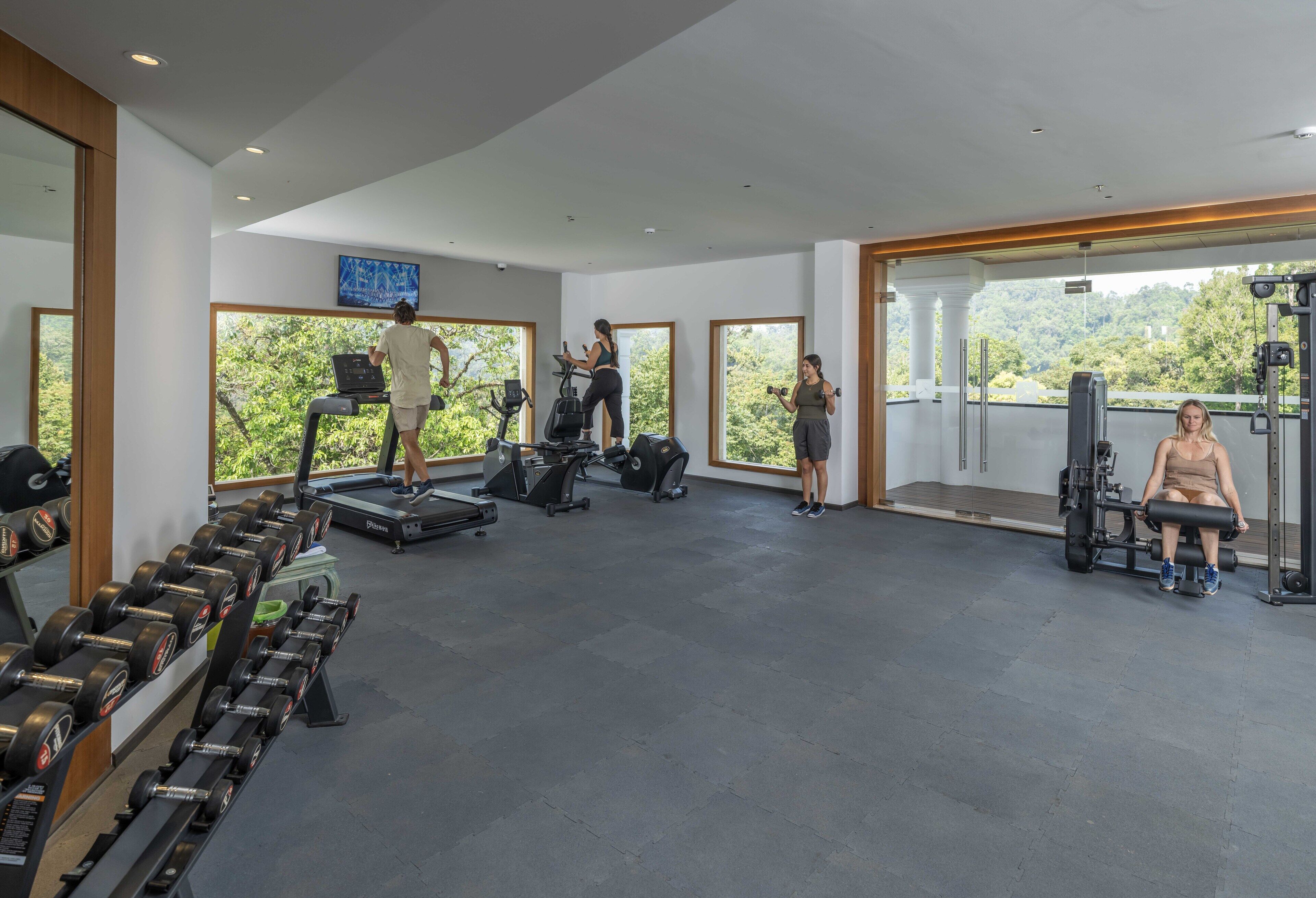 A spacious gym with treadmills, elliptical machines, and weightlifting equipment.