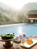 Una piscina al aire libre, sombrillas, sillones reclinables de piscina