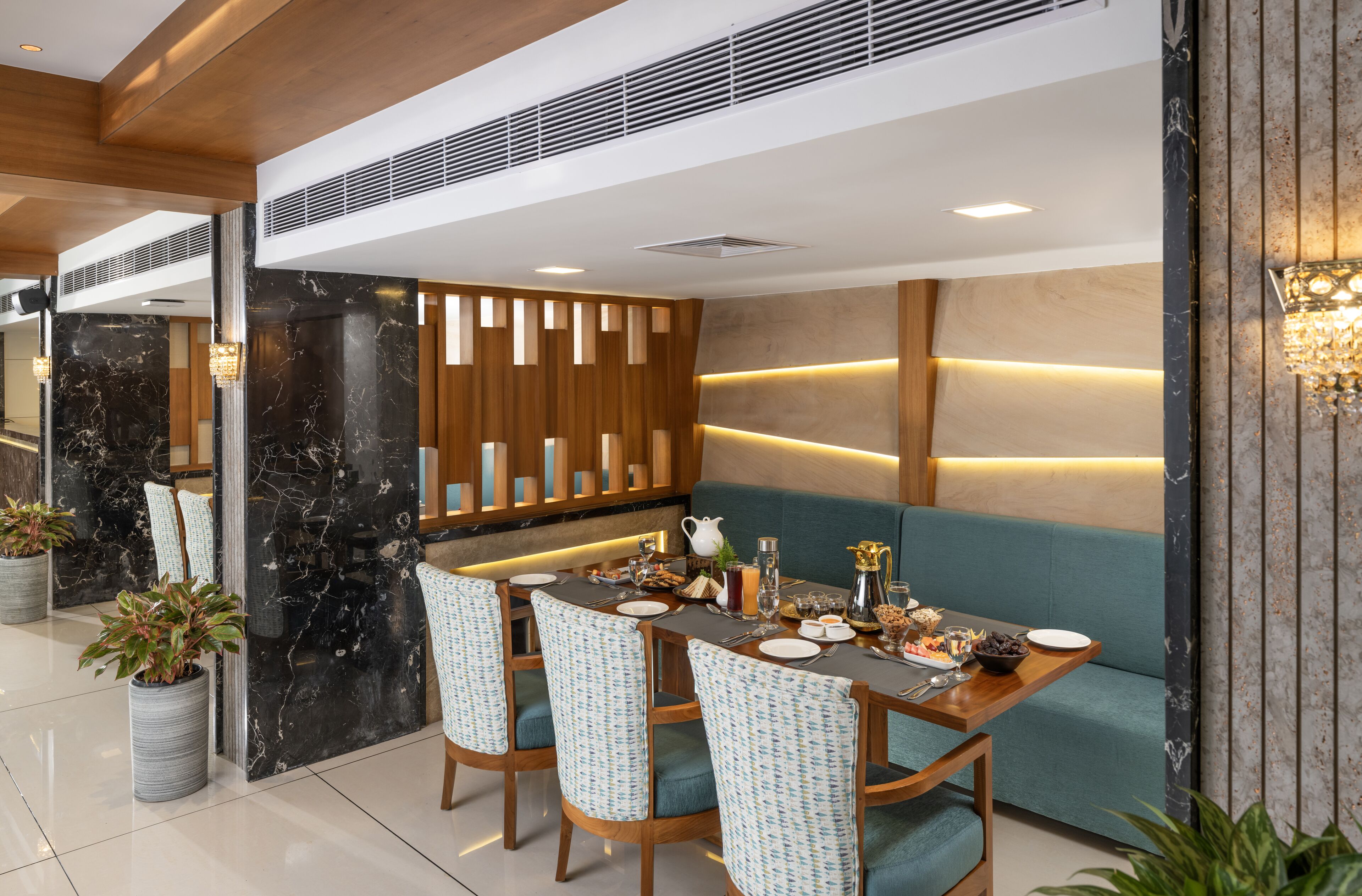 A modern dining area with a long table, chairs, and a seating area.