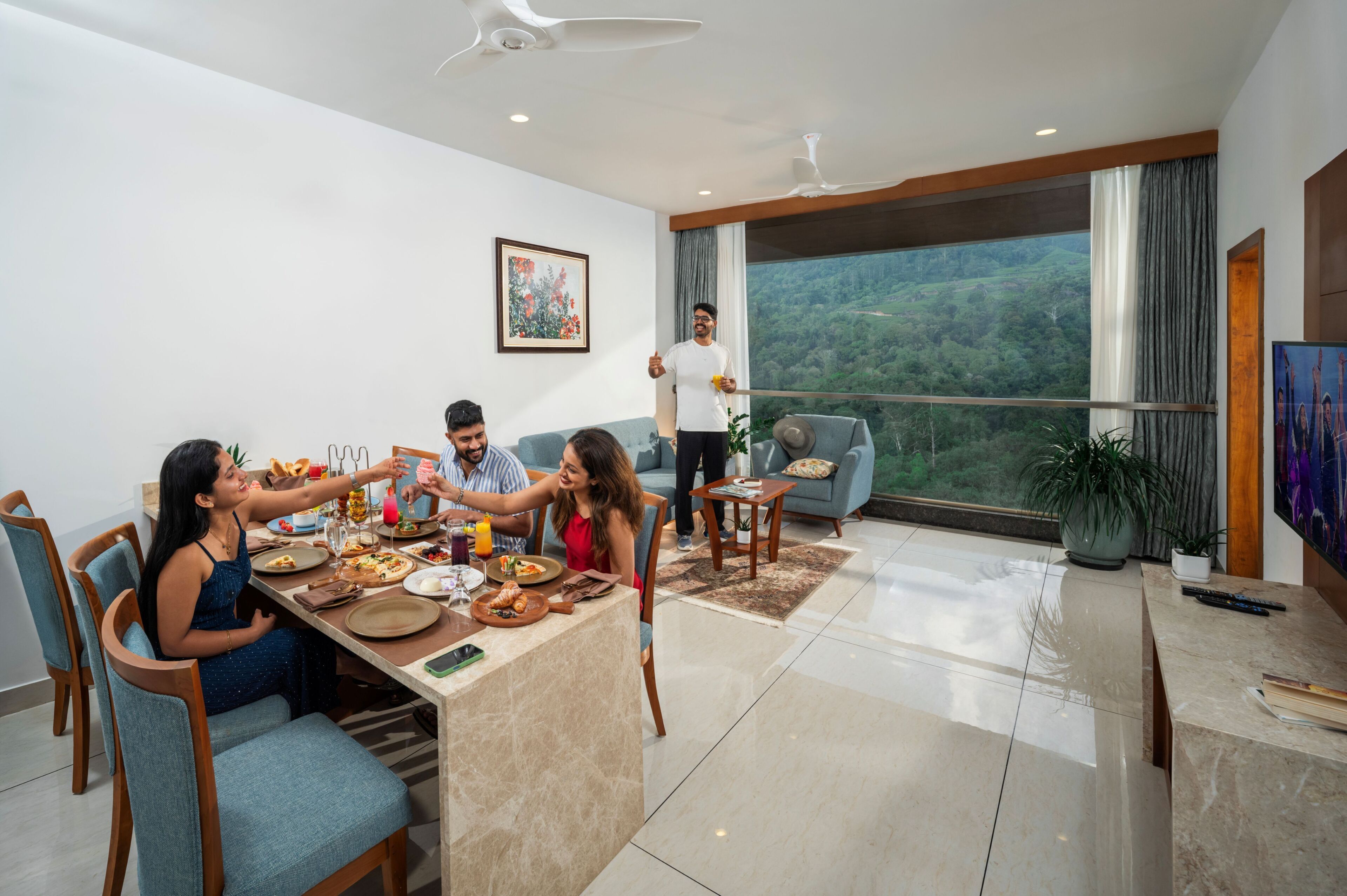 Una sala de estar moderna con comedor, un ventanal con vistas y un ventilador de techo.