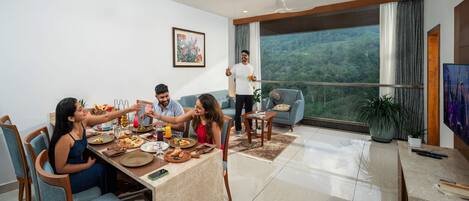 Una sala de estar moderna con comedor, un ventanal con vistas y un ventilador de techo.