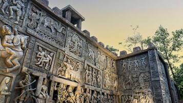 Escultura em pedra detalhada, com figuras e padrões intrincados.