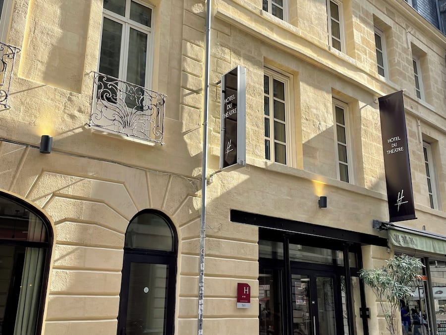 A hotel facade with a classic architectural style, featuring arched windows and a balcony with ornate metalwork.