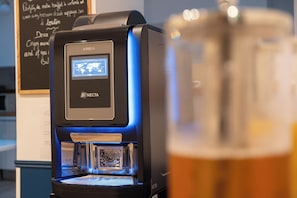 Una cafetera con pantalla digital y dispensador de café.