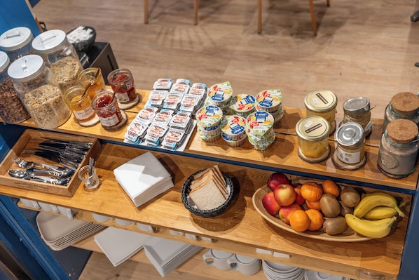 Un bufé de desayuno con diferentes alimentos y acompañamientos.