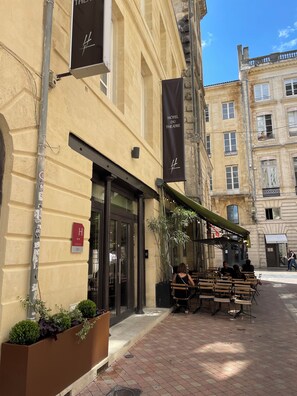 A hotel with a classic facade, outdoor seating, and a clear sky. - Hôtel du Théâtre (Bordeaux)