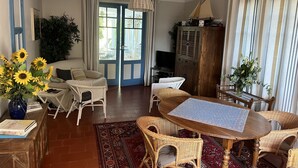 A cozy living room with a sofa, wicker chairs, a wooden table, and a TV. - Villa, Plein Coeur du Moulleau-arcachon, 8 Personnes (Arcachon)