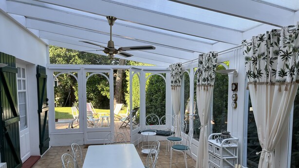 A covered patio with a table and chairs, a ceiling fan, and curtains. - Villa, Plein Coeur du Moulleau-arcachon, 8 Personnes (Arcachon)