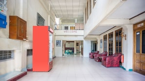 A spacious lobby with a 'WELCOME' sign, a red refrigerator, and red chairs. - OYO 2180 Vina Vira Hotel (Lhokseumawe)