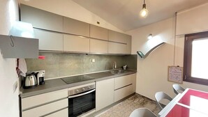 A modern kitchen with a built-in oven, a sink, and a countertop. There is a window providing natural light and a view of the outside. - H 51 FAMILY HOUSE  (Budoni)
