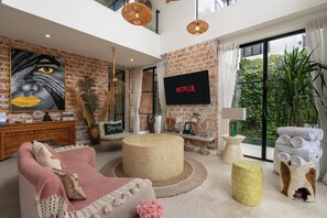 Villa | Oppholdsrom | En 55-tommers smart-TV med kabel-kanaler samt Netflix og filmkjøp