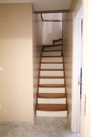 A staircase with wooden steps and white risers, leading to a landing. - Istanbul Relax Suite (Istanbul)