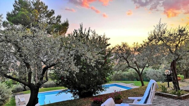 Un área junto a la piscina con dos sillones de descanso y una piscina pequeña.
