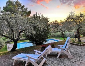 Un espace aménagé au bord de la piscine, avec deux chaises longues et une petite piscine.