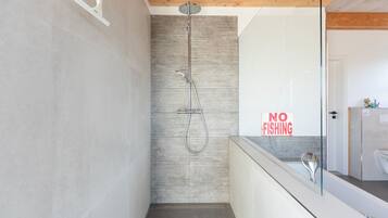 A modern bathroom with a shower, a 'NO FISHING' sign, and a wooden ceiling.