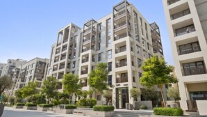A modern multi-story residential building with balconies, a well-maintained garden area, and a clear sky. - Silkhaus Surf 1 Dubai Creek Harbour (Dubai)