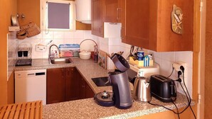 A compact kitchen with a sink, stove, and various appliances.