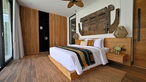 Un dormitorio moderno con una cama grande, paneles de madera, un adorno en la pared y vistas a través de un ventanal.