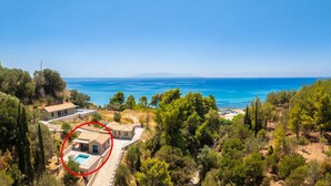 En ejendom ved kysten med swimmingpool, et stort hus og havudsigt.