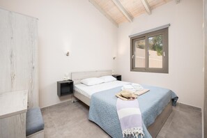 A bedroom with a bed, bedside tables, a window, and a wardrobe. - Villa Sia in Ionian Islands (Kefalonia)